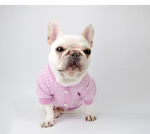 Elegant pink tweed dog sweater cardigan featured on a white French bulldog model