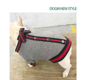 Vista dettagliata di un maglione grigio per cani con finiture in nastro a righe rosse e verdi