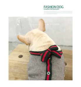 Dettaglio del maglione grigio per animali con fiocco a strisce rosse e verdi e bottoni