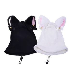 Close-up of black and white knitted cat ear helmet covers featuring bows and small golden bells