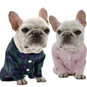 Détail de bouledogges français portant des pyjamas pour animaux à carreaux et rayures roses
