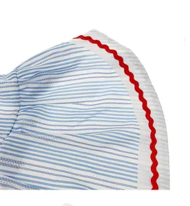 Close-up of blue and white striped pet dress hem with red wavy ricrac trim detail