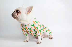 Detailed side view of a white French Bulldog wearing pink carrot print dog pajamas outfit