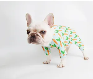 White French Bulldog wearing light blue four-legged pet pajamas with carrot print