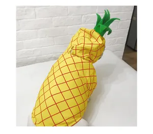Detailed back view of a dog wearing a bright yellow pineapple costume with green leaf hood