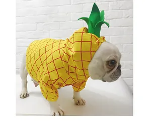 Detailed side view of a French Bulldog wearing a bright yellow pineapple pet costume