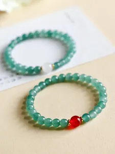 Detailansicht von grünen Chalcedon-Perlenarmbändern mit rotem Achat und Goldakzenten