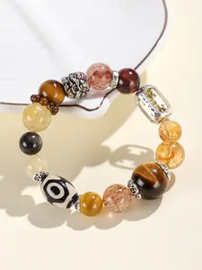Makrodetail von Tigerauge- und Super-Seven-Perlen auf einem handgefertigten Armband.
