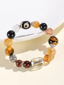 Detail eines Edelsteinarmbands mit Tigeraugenperlen und gravierten Silberanhängern.