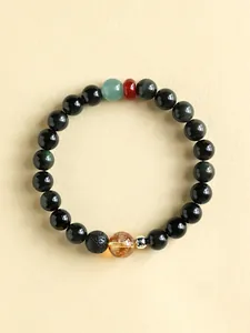 Close-up detail of obsidian beaded bracelet featuring yellow citrine and red agate stones