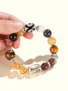 Detaillierte Ansicht eines Perlenarmbands mit Tigerauge, Dzi-Perle und Silberanhängern