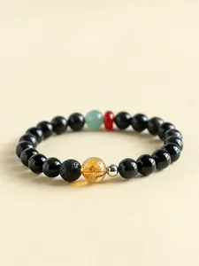 Detailed view of a beaded bracelet with black obsidian and yellow crystal accents.