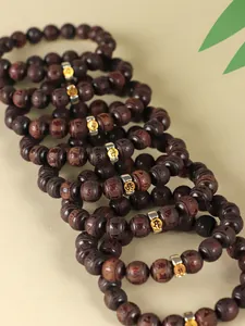 Detailed view of handcrafted dark sandalwood zodiac bead bracelets with metallic charms
