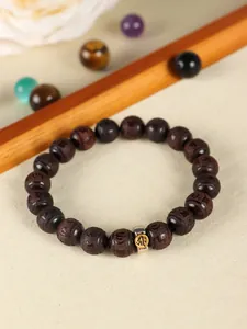 Detailed view of sandalwood beaded bracelet with engraved Buddhist mantra symbols