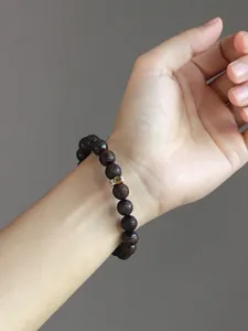 Handcrafted vintage sandalwood bead bracelet featuring traditional zodiac carvings on a wrist