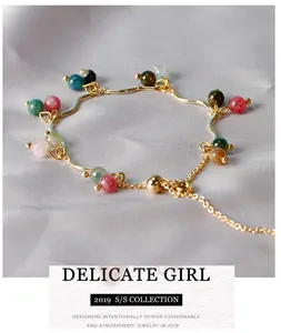 Vista dettagliata di un bracciale dorato con perline di pietre naturali colorate