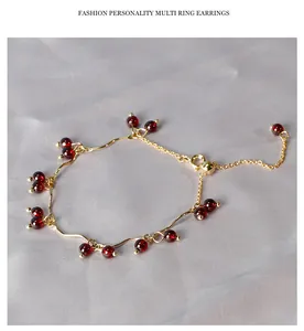 Vista macro di bracciale in perle di granato con catena dorata ondulata su seta