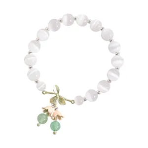 Elegante pulsera de cuentas de ojo de gato blanco con dijes de hojas y flores
