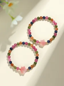 Vista detallada de dos pulseras de cuentas de turmalina de colores con dijes de estrellas.