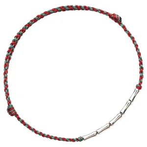 Handcrafted braided red and green cord bracelet with silver bamboo joints on white background.