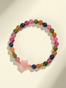 Detalle de una pulsera de cuentas de turmalina de colores con un dije de estrella rosa elegante.