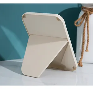 Detailed back view of a minimalist foldable makeup mirror with adjustable stand mechanism
