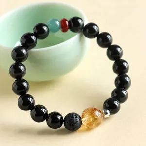 Elegant obsidian and rutilated quartz beaded bracelet with vintage lava stone accents.