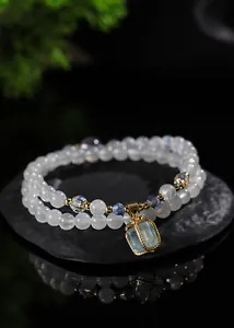 Vista macro detallada de pulsera de piedra lunar de doble capa con colgante de aguamarina