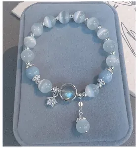 Detalle de una pulsera de cuentas de ojo de gato azul claro con colgante de estrella