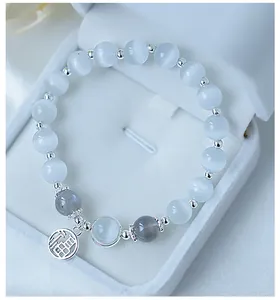 Detalle de pulsera de cuentas de ojo de gato con colgante de la suerte Fu de plata