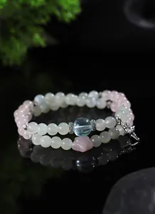 Primer plano de elegante pulsera de cuentas con piedra lunar, aguamarina y cuarzo rosa