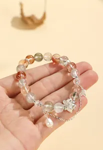 Primo piano del braccialetto di perline di loto in stile cinese con cristalli tenuto in mano.