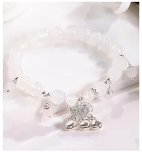 Primer plano de pulsera de ojo de gato blanco con colgante de candado de paz plata