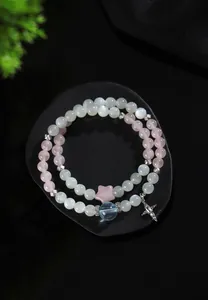 Detalle macro de pulseras de cuentas de piedra de luna azul y cuarzo rosa con estrella