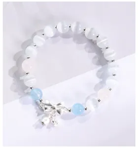 Primer plano de pulsera de cuentas de ojo de gato con lazo de plata y dijes de lirio.
