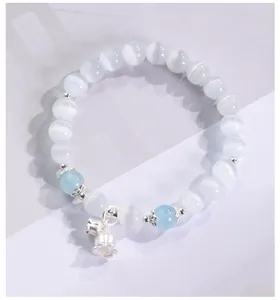 Primer plano de pulsera de cuentas de ojo de gato con dije de flor plateada