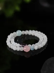 Primer plano detallado de una pulsera de piedra de luna de doble hilo con gemas pastel