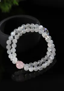 Detalle macro de una elegante pulsera de doble hilo de piedra lunar y cuarzo rosa