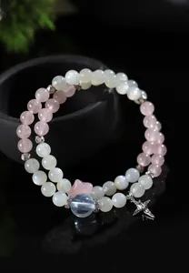 Primer plano de pulsera de doble hilera con piedra de luna, cuarzo rosa y dije de estrella