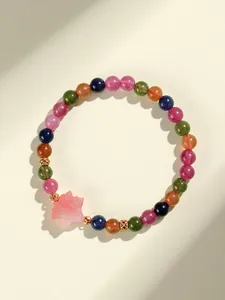 Imagen detallada de una pulsera de turmalina colorida con dije de hoja de arce rosa