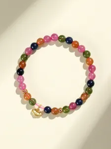 Exquisita pulsera de cuentas de turmalina multicolor con detalle de dije ruyi de oro fino.