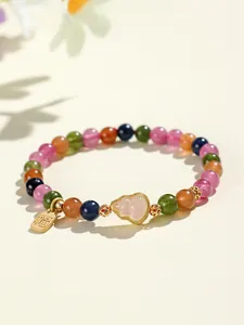 Detalle de pulsera de cuentas de turmalina de colores con amuleto de cuarzo rosa