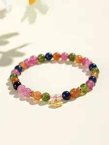Vista detallada de la pulsera de cuentas de turmalina de colores con amuleto dorado