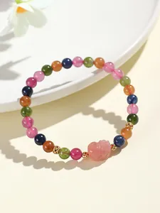 Primer plano de pulsera de cuentas de turmalina multicolor con dije de Pixiu rosa