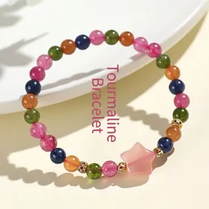 Pulsera artesanal de cuentas de turmalina de colores con un dije de estrella rosa