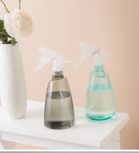 Detailopname van twee moderne plastic spuitflessen in grijs en blauwgroen voor kamerplanten