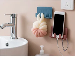 Detailed view of multi-functional wall mounted adhesive storage rack holding phone and bath loofah