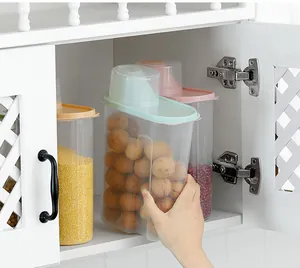 Close-up of a large plastic food storage container being taken from a white kitchen cabinet