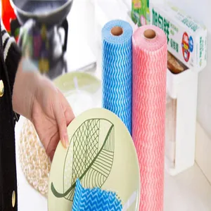 Detail of disposable non-woven dishcloth with wavy pattern wiping a ceramic plate