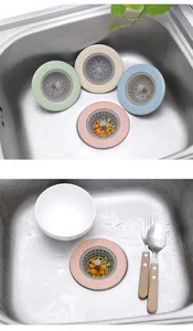 Kitchen sink strainer detail showing multi-color anti-clogging filter with food residues